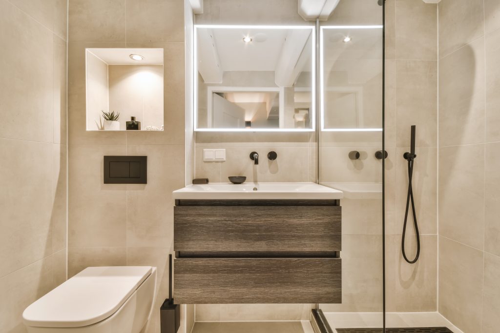 A recently decorated modern white bathroom with a washbasin, mirror, shower room, and toilet.