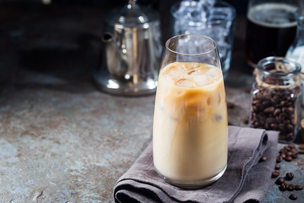 A tall glass of iced coffee. Dairy is known to cause bloating.