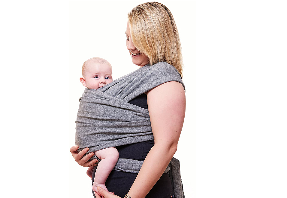 A mother holding her baby close to her chest using the Funki Flamingo Baby Wrap. Hands-free baby carrier in grey color. White background. 