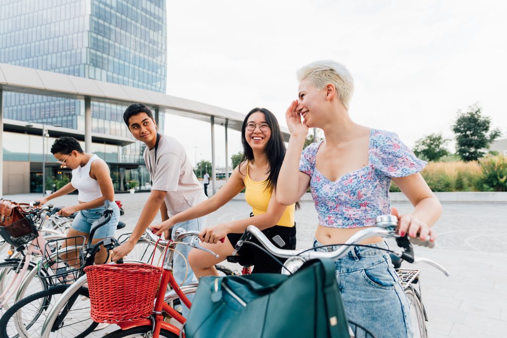 A group of multiethnic friends cycling in a city. Concept of sustainable travel, cycling, and sustainability. 