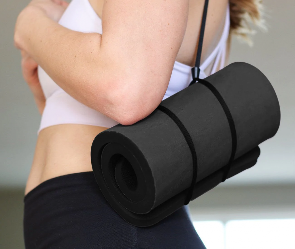 Woman carrying rolled up YogaPaws PawPad. concept of best yoga equipments. 