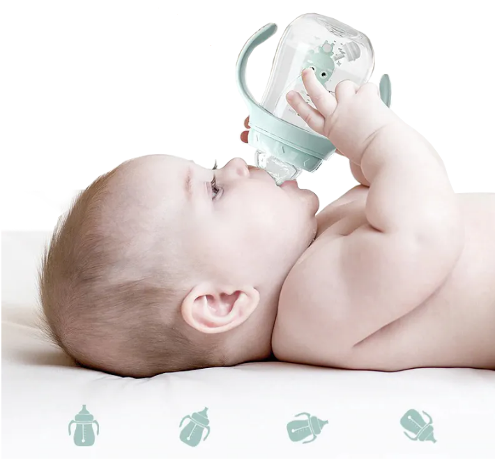 A baby lying down and drinking from a SuperTots Baby Bottle. 